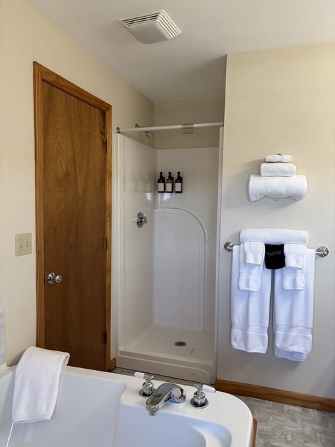 Clean bathroom with a shower-tub combination, fresh towels, and complimentary toiletries for a comfortable stay.