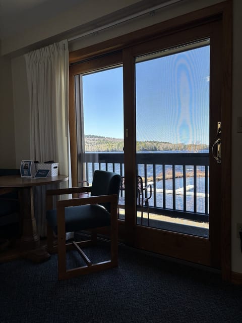Cozy seating area with a private waterfront balcony and beautiful lake views, perfect for relaxing and enjoying the scenery.