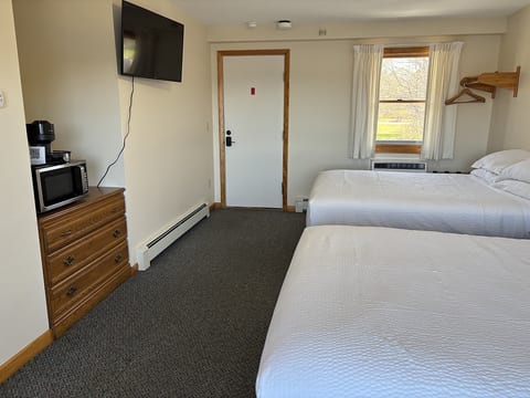 Bedroom with two queen beds, TV, microwave, and coffee maker.