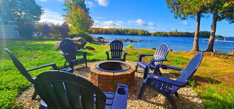 Waterfront fire pit with Adirondack chairs, lake views, and the perfect spot to relax by the water.