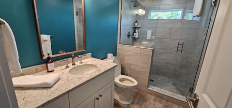 Modern bathroom with a walk-in glass shower, stylish finishes, and fresh towels for a comfortable stay.
