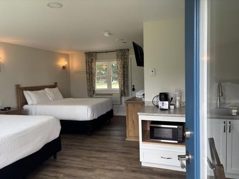 Spacious studio suite with two queen beds, a kitchenette, and modern comforts for a relaxing stay.