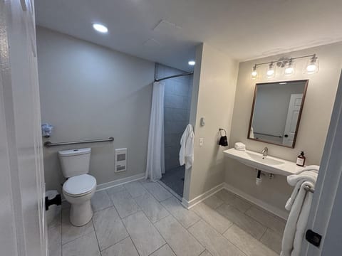 Modern bathroom with a walk-in shower, fresh towels, and clean contemporary finishes.
