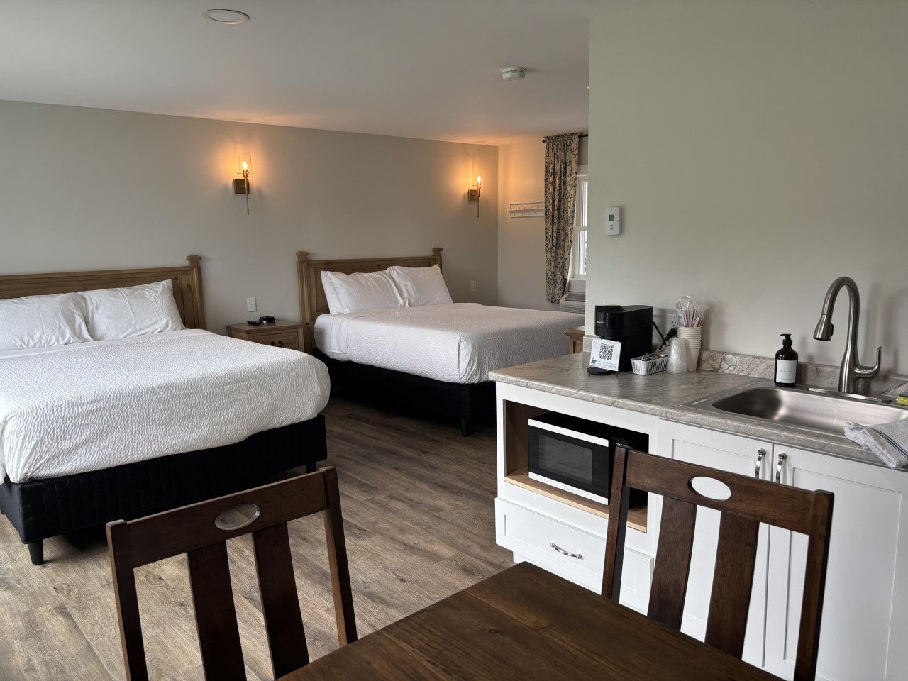 Spacious studio suite with two queen beds, a kitchenette, and comfortable accommodations for families or groups.
