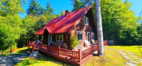 Charming cabin retreat with a spacious deck and peaceful forest surroundings.