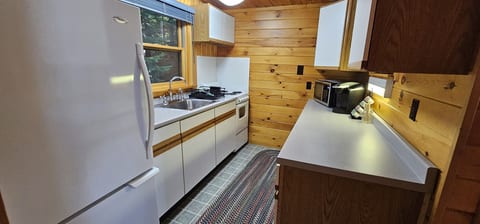 Fully equipped cabin kitchen with modern appliances, ample counter space, and warm wood accents for easy meals during your stay.