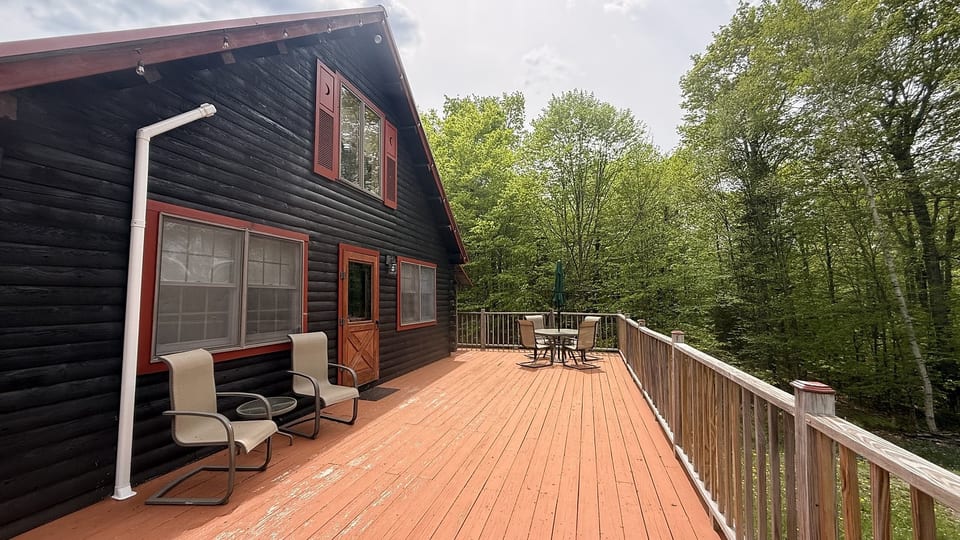 Spacious wraparound deck with outdoor seating, peaceful forest views, and the perfect setting for relaxing cabin getaways.