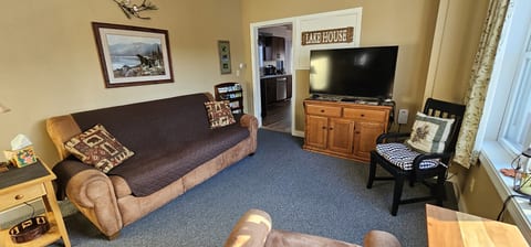 Cozy living room with a futon, TV, and comfortable seating.