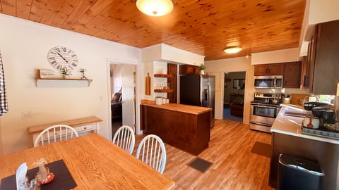Open kitchen and dining area with modern appliances and wood finishes.