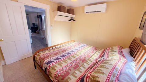 Comfortable king bedroom with rustic cabin décor, plush bedding, and convenient in-room climate control for a relaxing and restful stay.