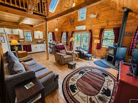 Rustic log cabin with vaulted wood ceilings, cozy wood stove, and warm mountain lodge charm.
