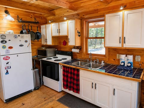 Rustic cabin kitchen with cozy wood interiors, full amenities, and charming lodge-style design.