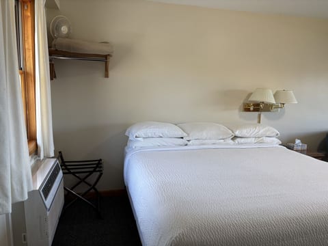 Bright king bedroom with soft lighting, white bedding, and cozy lodge-style comfort.