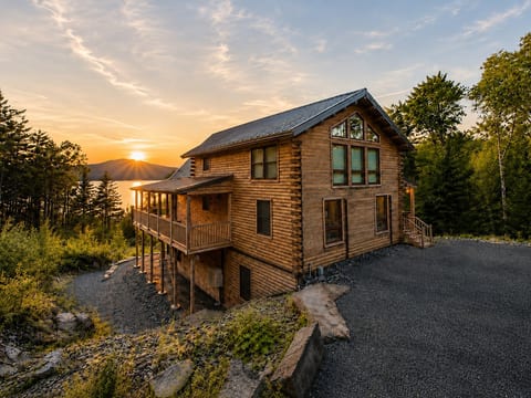 Stunning log cabin surrounded by nature with beautiful sunset views over the water and mountains.