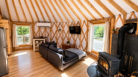 Cozy luxury yurt with a wood stove, modern comforts, and peaceful forest views.