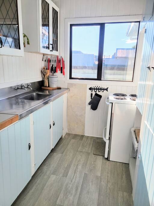 Original galley kitchen complete with original cupboards. Has oven, microwave, fridge/freezer, cooking pots and pans. Cleaning supplies. 