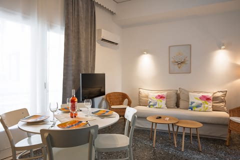 Bright living-dining space with cozy seating, natural light, and AC