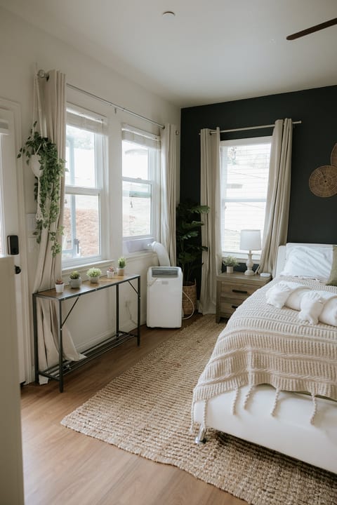 Bright, cozy bedroom with tall windows, soft linens, and modern styling