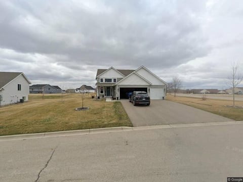 Spacious suburban home with large yard, wide driveway, and attached garage
