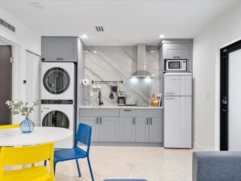 Fully equipped kitchen and laundry in Miami, Florida, featuring stacked washer/dryer, modern appliances, marble countertops, and everything you need for a comfortable long-term or short stay.