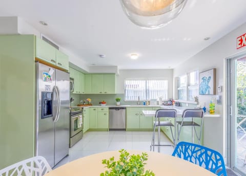 Light green kitchen in Dania Beach with modern appliances—ideal for extended stays.