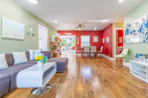 This open-concept living and dining space features bold colors, cozy seating, and natural light.