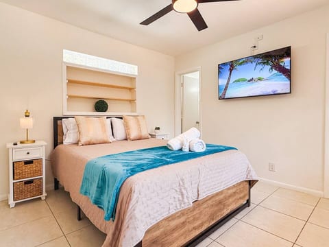Unwind in this serene bedroom with a plush bed, TV & cozy vibes for restful nights.