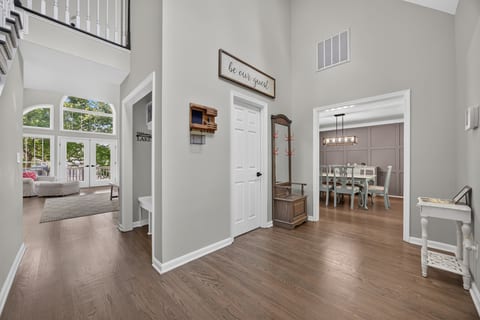 Grand entryway with soaring ceilings, natural light, and open living spaces