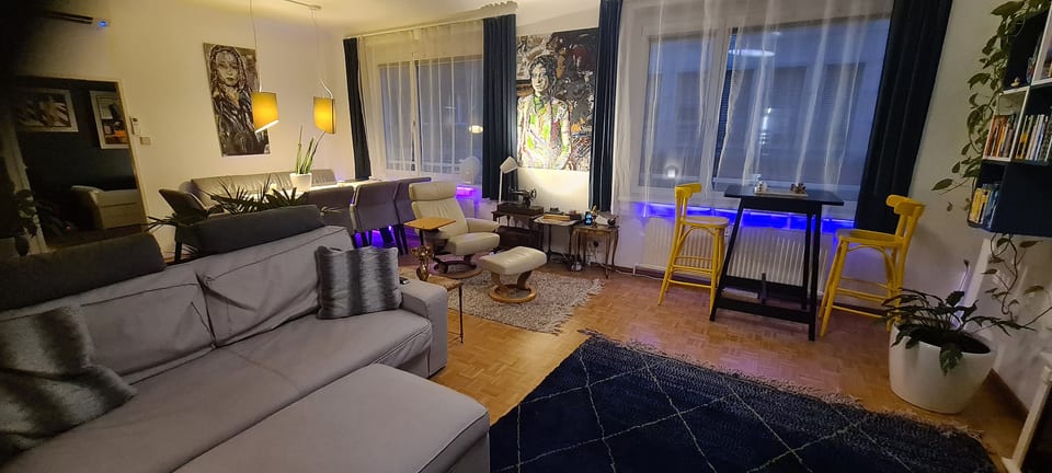 Stylish open living space with cozy seating, artful decor, and ambient lighting