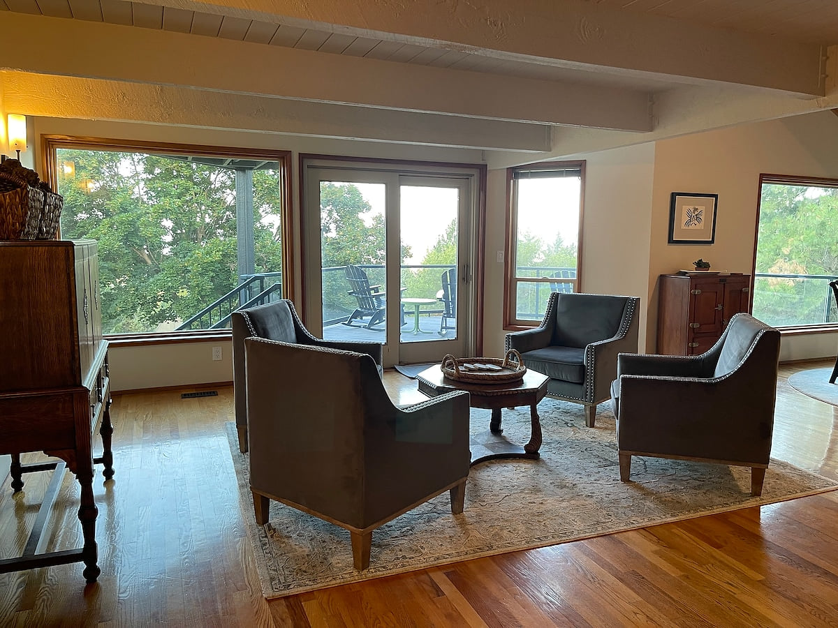 Living Room: Comfortable club chairs next to the ledge stone fireplace. Large picture window. Deck access. Spacious South Hill View Home, Quiet Setting + Spa