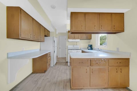 Kitchen with fridge and stove with window at the kitchen sink.