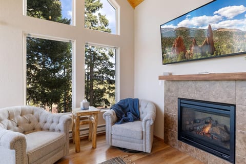Living room with fireplace- has two-barrel chairs, a bench and a leather couch with a recliner on each end. It's super comfortable!