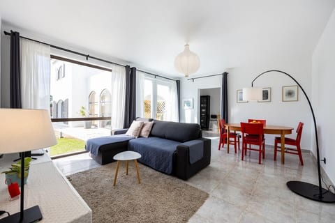 Living room with a view and access to the shared garden. Features a sofa with chaiselong which can be turned into a sofa bed, HD TV with Chromecast, light and dark curtain shades and a portable fan.