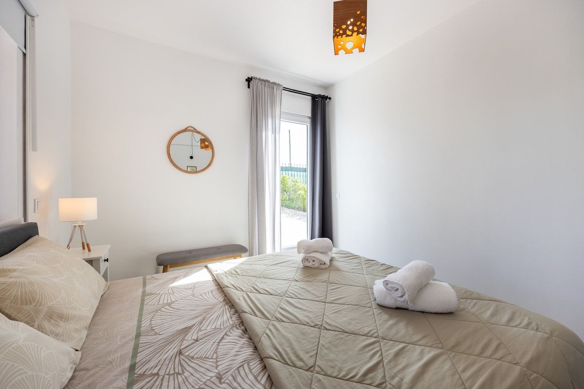 The bedroom features a large door that can tilt for ventilation or open for access to the outside.