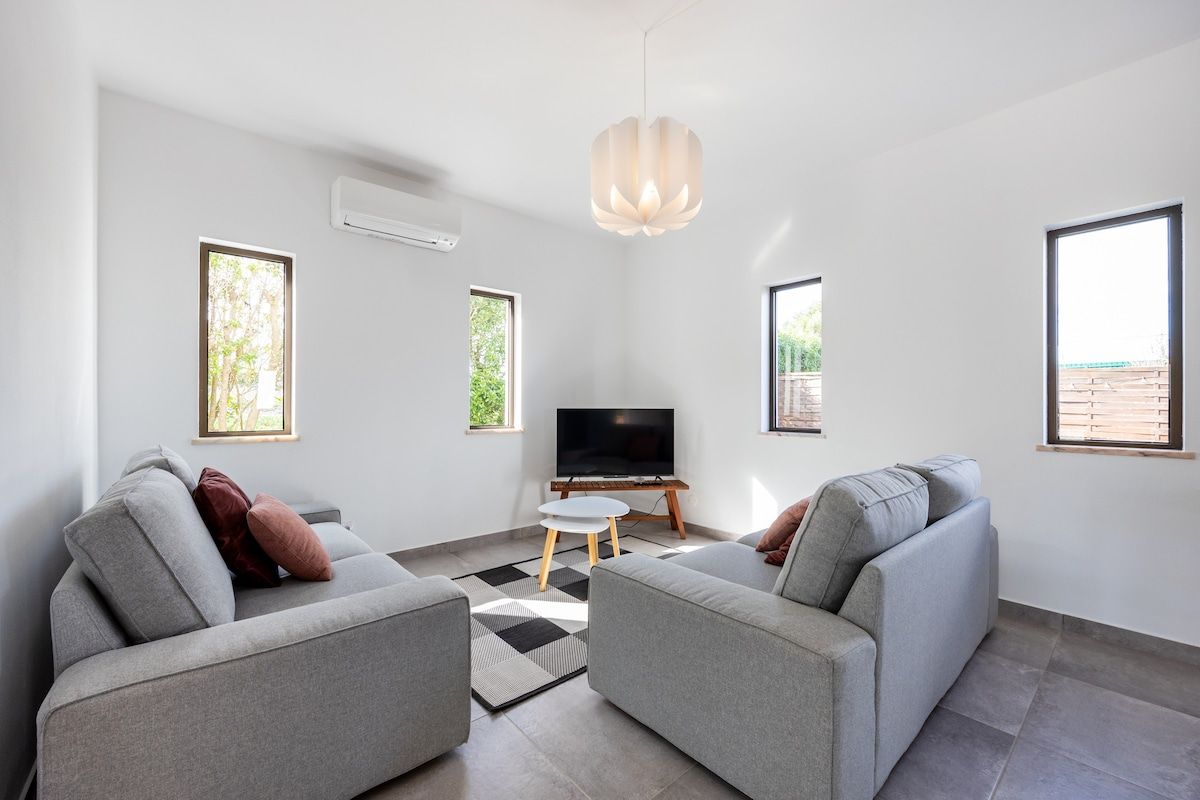 Living room with TV, 2 2-person couches, very luminous views to the private garden area