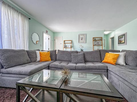Enjoy stylish comfort in Hollywood, Florida! This bright living room features a sleek gray sectional, vibrant accents, and modern décor—perfect for relaxing after beachside adventures. Ideal for families or couples seeking a cozy, well-appointed stay