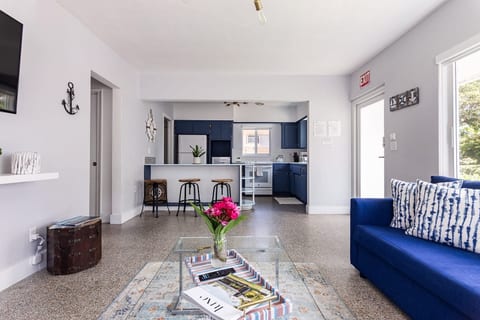 Relax in Hollywood, Florida! This open-concept space with bold blue accents, cozy seating & a stylish kitchen is perfect for couples, families, or long-term guests seeking comfort, charm, and a beautifully designed home base near the beach.