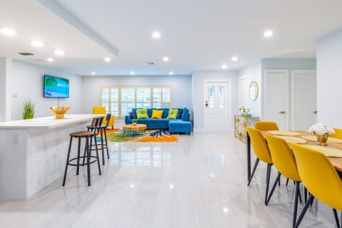 Enjoy a colorful open-concept space with a cozy sectional, stylish dining area, and sleek kitchen.