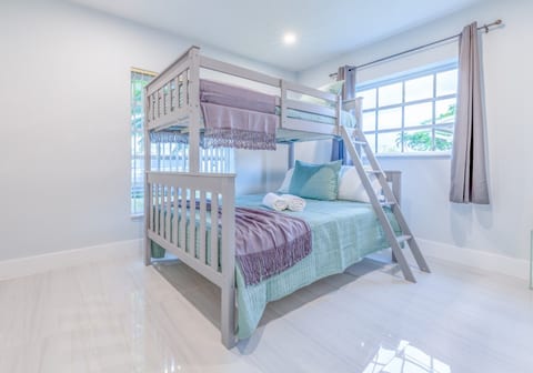 Bright bunk room with cozy bedding, natural light & a guest-ready setup.