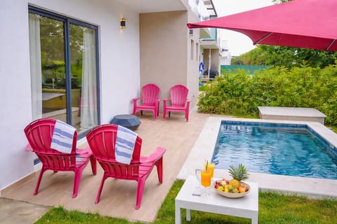 Covered patio with pink lounge chairs—relax in the shade by your private pool.