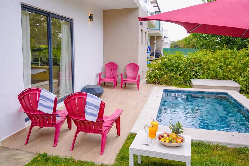 Covered patio with pink lounge chairs—relax in the shade by your private pool.