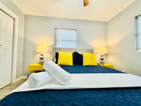 Recharge in style! This cozy  Lakeland, Florida, bedroom features bold navy and sunny yellow accents, plush linens, and warm lighting—perfect for unwinding after a day of exploring Lakeland or Clearwater. Comfort meets charm in every corner.