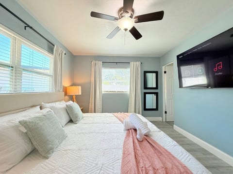 Relax in Orlando, Florida! This peaceful bedroom features pastel accents, cozy bedding, natural light & a mounted TV—perfect for couples, solo travelers, or long-term guests seeking comfort, style, and a restful retreat near top attractions.