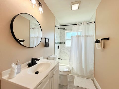 Unwind in Orlando, Florida! This modern bathroom features marble-style tile, sleek black fixtures, and natural light—perfect for couples, families, or long-term guests seeking comfort, cleanliness, and a touch of contemporary elegance.