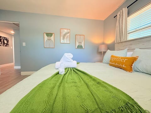 Feel at home in Orlando, Florida! This serene bedroom with soft blue walls, cozy green throw & a cheerful “Together” pillow is perfect for couples, solo travelers, or long-term guests seeking warmth, comfort, and a welcoming retreat.