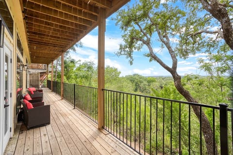 Enjoy stunning tree-top views from this spacious private balcony, perfect for morning coffee. Wicker seating invites you to relax in a peaceful, scenic view.
