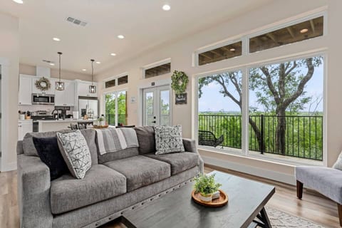 Bright and cozy living room with beautiful tree-lined views! This inviting space features plush seating, a large smart TV, and stylish decor—perfect for relaxing after a day exploring Gruene. Floor-to-ceiling windows bring the outdoors in!