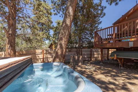 Private hot tub in the fenced backyard, shaded by pines for a soak after the slopes.