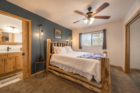 Bedroom w/ log-frame bed, cozy quilt & en-suite bath just steps away.