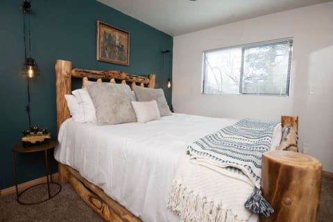 Inviting bedroom w/ plush bedding, wood accents, and soft light for restful nights.